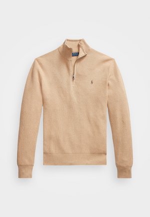 Suéter de color beige con cuello de media cremallera, puños y dobladillo acanalados, que presenta una tela texturizada y un pequeño logo en el lado izquierdo del pecho.