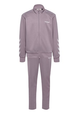 Hellviolette Sportjacke mit Reißverschluss und passende Hose mit weißen Chevron-Streifen an den Ärmeln und "hummel"-Logos auf Brust und Oberschenkel.
