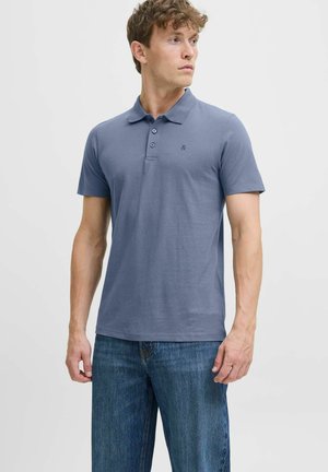 Kurzarm-Polohemd aus einfarbigem, hellblauem Baumwollstoff mit einer Knopfleiste mit drei Knöpfen und einem kleinen gestickten Logo auf der Brust.