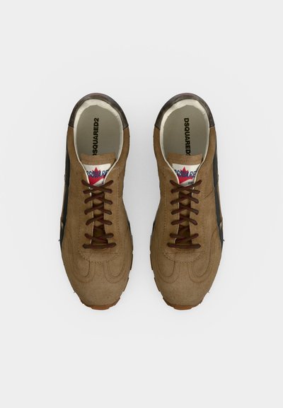 Paire de baskets en daim marron avec des lacets foncés et des détails noirs, vue de dessus sur fond blanc.