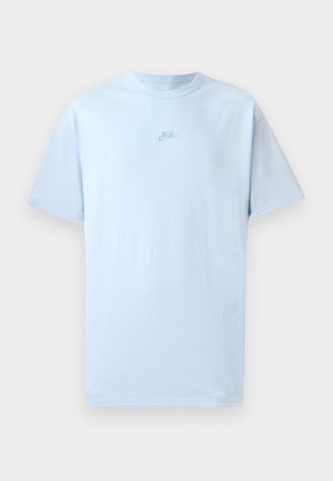 Nebo modra bombažna majica s kratkimi rokavi, okroglo izrezana in z izvezenim logotipom Nike v nekoliko temnejši modri barvi na prsih.