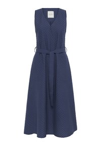 Marineblauwe mouwloze wikkeljurk met een V-hals, textuurstof, zijzakken en een riem om de pasvorm aan te passen. Heeft een uitlopende rok.