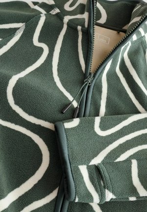 Giacca in pile verde con un motivo astratto bianco; presenta una zip completa, tasche laterali e una superficie texture.
