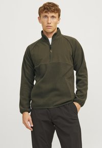 Olive green fleece pullover with a half zip, featuring a textured lower panel and smooth upper section, relaxed fit, and long sleeves.
