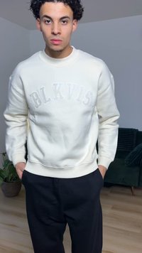 Kermanvärinen collegepusero, jossa on vaaleanharmaalla kirjailtu "BLKVIS", yhdistetty mustiin housuihin. Sileä pinta, rento istuvuus sekä resorit kaula-aukossa ja hihansuissa.