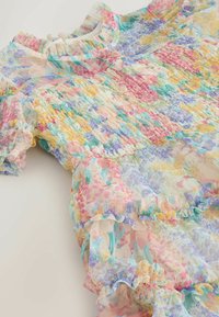 Vestito floreale multicolore realizzato in tessuto leggero con dettagli arricciati, maniche arricciate e corpetto aderente. Presenta tonalità rosa, blu e giallo.