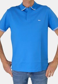 Polo shirt blu in cotone di colore solido, con colletto e polsini bianchi a contrasto con strisce. Piccolo logo sul petto.