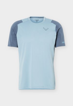 Hele sinist lühikeste varrukatega spordisärk tumedamate siniste õlgade ja varrukatega, millel on rindkerel mägikassi logo ja varrukal "DYNA".