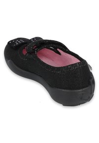 Czarne buty z tkaniny o fakturowej powierzchni, z różowym wnętrzem, ozdobną kokardką oraz solidną czarną podeszwą.