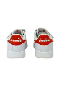 Sneaker bianche con accenti rossi, caratterizzate da una superficie testurizzata, suola in gomma e un logo sul tallone. Design classico a basso profilo.