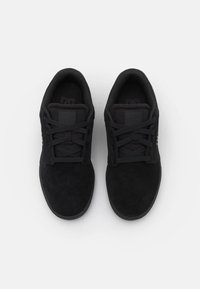 Black suede sneakers featuring a low profile, round toe, and flat laces. Padded collar and tongue with a textured sole for traction.