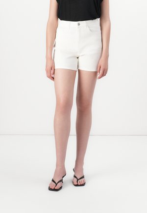 Lys beige denimshorts med høy midje, frontlommer, en baklomme og knappelukking. Kombinert med svarte flip-flops.