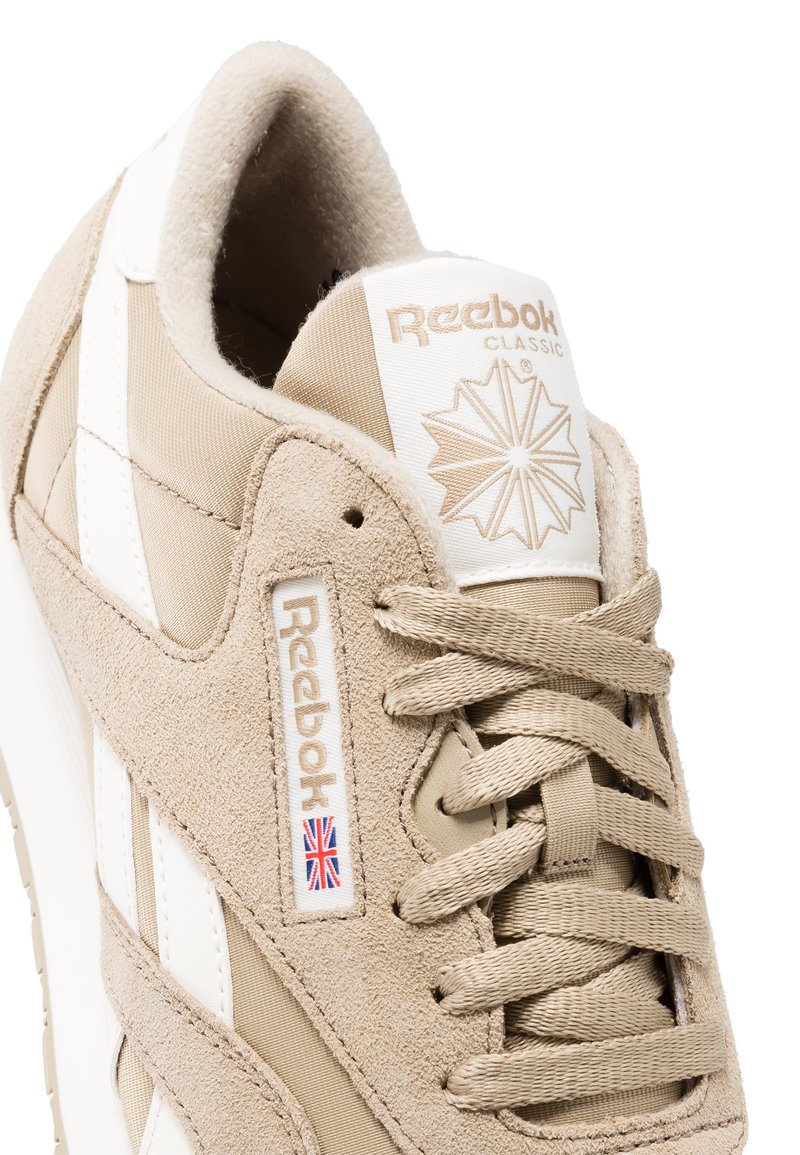 Baskets Reebok Classic beiges en suede et mesh, avec des accents blancs, des lacets ronds et un logo sur la languette et sur le côté.