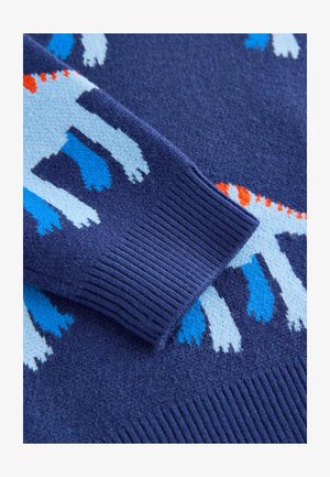 Maglione lavorato a maglia con base blu navy, polsino testurizzato decorato con motivi animali blu e bianchi e accenti arancioni.