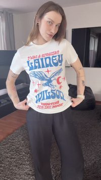 Λευκό βαμβακερό μπλουζάκι με μπλε γραφικό αετού και κόκκινο κείμενο που γράφει "Lainey Wilson Shooting for the Moon" με διακριτικά αστέρια.