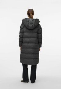 Langer schwarzer Puffer-Mantel mit Kapuze, mit gestepptem Design und seitlichen Taschen, von hinten betrachtet. Das Material wirkt glatt und matt.