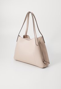 Borsa in pelle beige con una texture liscia, forma arrotondata e cuciture scure a contrasto. Due manici lunghi per indossarla a spalla.
