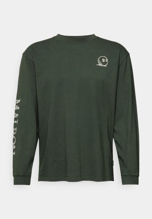 Camisa de algodón verde oscuro de manga larga con cuello redondo, que presenta un pequeño gráfico blanco en el pecho y un diseño de texto blanco en la manga.