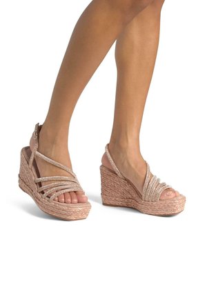 Sandaletter med kilehæl i et vævet pink materiale, prydet med flere glitrende stropper over foden. Holdbar sål med en struktureret overflade.