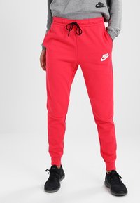 Röda mjukisbyxor med elastisk midja och dragsnöre, med sidofickor och en vit Nike-logga på vänstra låret.