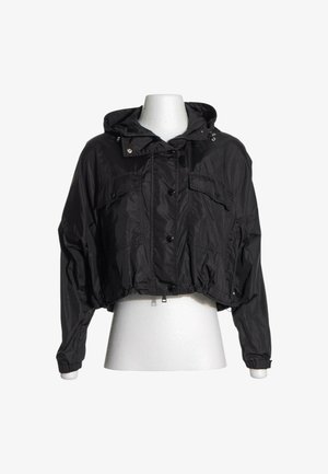 Schwarze kurze Kapuzenjacke mit vorderen Knöpfen, zwei Brusttaschen und elastischen Bündchen auf einem weißen Schaufenster-Torso.