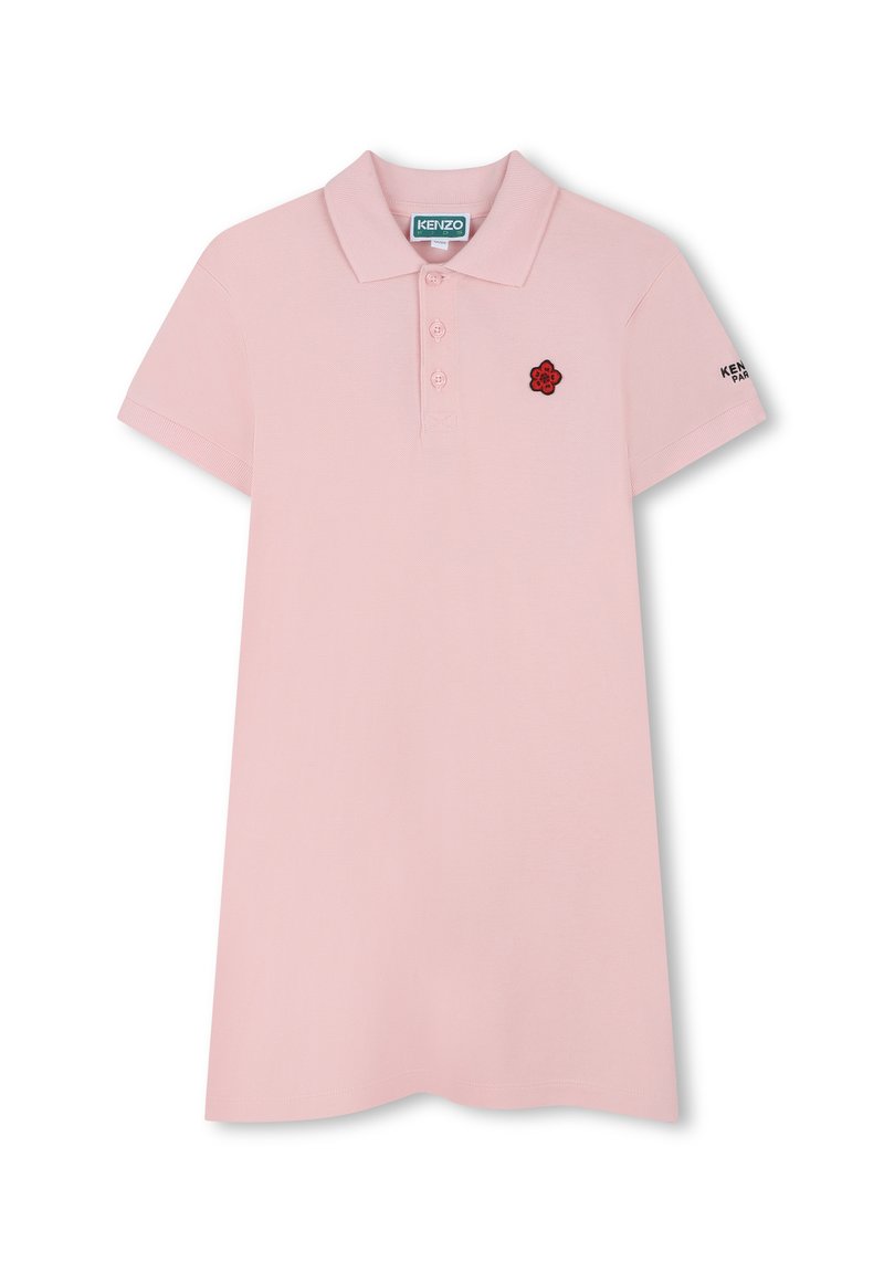 Polo rose avec un col classique, une patte de boutonnage à quatre boutons, des manches courtes et un logo de fleur rouge brodé sur la poitrine. Texture lisse.