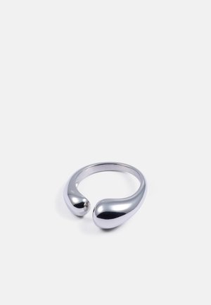 Bague en métal argenté avec une surface lisse et polie ; présente deux extrémités bulbées créant un design ouvert. Intérieur rond.