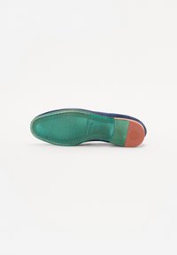 Talpa de pantof din piele verde cu accente albastre, având detalii de cusătură și un toc roșu. Textură netedă, formă rotundă și un logo discret imprimat.