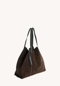 Sac en daim marron avec des straps en cuir foncé, présentant une forme triangulaire, des coutures contrastantes et une touche de pompon.