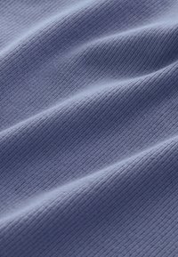 Tekstureret, rynket stof i en blød blå nuance med lodrette ribber, der viser en glat, let skinnende overflade.