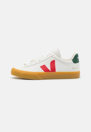 Sneaker bianco con dettagli rossi e verdi, realizzato in pelle liscia. Presenta una suola in gomma e cuciture decorative, con etichetta "VEJA" sul tallone.