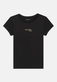 Juodas trumpomis rankovėmis marškinėliai, pagaminti iš minkštos medvilnės. Dėl apvalios iškirptės ir aukso siuvinėjimo "Calvin Klein NEW YORK" logotipo ant krūtinės.