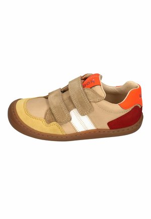 Beige sneaker with yellow toe, red heel, white stripes, orange accents, and two beige Velcro straps on a brown sole.
