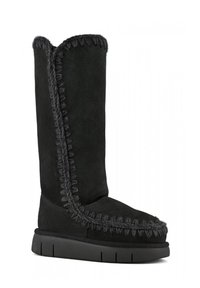 Stivale in suede nero caratterizzato da un design alto, cuciture grigie a contrasto e una robusta suola in gomma nera con scanalature orizzontali.