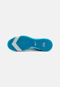 Semelle de chaussure de sport bleue avec une surface texturée, présentant un motif en zigzag et une bande d'accent blanche. Logo Nike au centre.