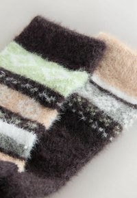 Többszínű kötött szövet, amely sötétbarna, világoszöld, bézs és fehér csíkokkal rendelkezik, puha, bolyhos textúrával és finom mintákkal.