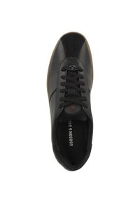 Zapatilla de cuero negra con detalles de ante, puntera redonda y suela de goma de contraste. Presenta un cierre de cordones y un logo en la lengüeta.