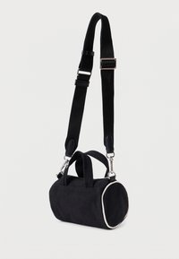Μαύρη κυλινδρική τσάντα ώμου με αποσπώμενο ρυθμιζόμενο ιμάντα, δύο κοντές λαβές και λευκή επένδυση κατά μήκος των στρογγυλών άκρων.