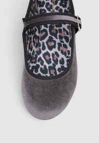 Zapatos planos Mary Jane de terciopelo gris con una correa elástica negra y hebilla plateada. Plantilla con estampado de leopardo en tonos de negro y acentos en rosa.