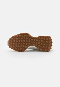 Baskets blanches avec une semelle extérieure en caoutchouc gomme texturée présentant des motifs circulaires. Matière supérieure lisse avec des éléments de design intégrés.