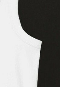Des pièces de vêtements blanches et noires se chevauchent, mettant en valeur des détails de coutures courbes et des couleurs de tissu contrastées.