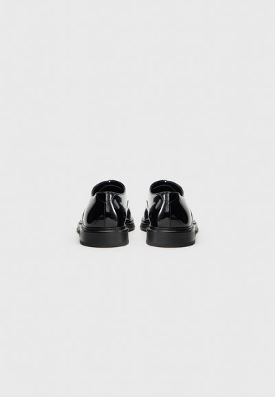 Fekete, lakkbőrből készült cipők, sima, fényes felülettel, kerek orral és alacsony, fekete gumitalppal. Csúszásmentes kivitelben.