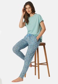 Lichtblauw katoenen t-shirt met een eenvoudig ontwerp, gecombineerd met blauwe bloemenbedrukte broek met een elastische tailleband en trekkoord.