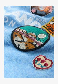 Unselected, light blue badge embroidery