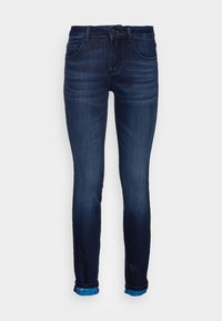 Pantalones vaqueros skinny de mezclilla azul oscuro con una cintura de altura media, diseño de cinco bolsillos y puños enrollados para un detalle adicional. Textura suave y ligero desgasten.