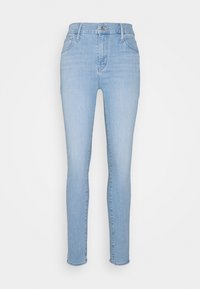 Jeans de mezclilla azul claro, ajuste slim, con cintura alta, cinco bolsillos y cierre de cremallera. La tela tiene una textura suave con desgaste mínimo.