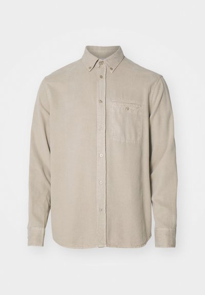 Camicia beige a maniche lunghe realizzata in tessuto morbido, con colletto a punta, tasca anteriore e chiusura a bottoni lungo la patta.
