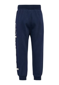Marineblauwe sweatpants met een elastische tailleband, taps toelopende enkels en een groot gedrukt tekstontwerp aan één kant. Katoenen materiaal met een zachte textuur.