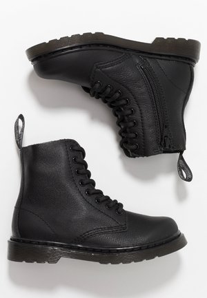 Černé kožené kotníkové boty s šněrováním vpředu a detaily se zipem. Mají texturovaný povrch a silnou, vroubkovanou podrážku.
