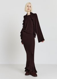 Long brown dress with ruffled accents at the neckline and hem, paired with a matching open cardigan; smooth, soft knit material.